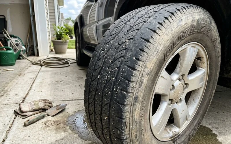 Close-up of a feathered, unevenly worn tire tread, natural light