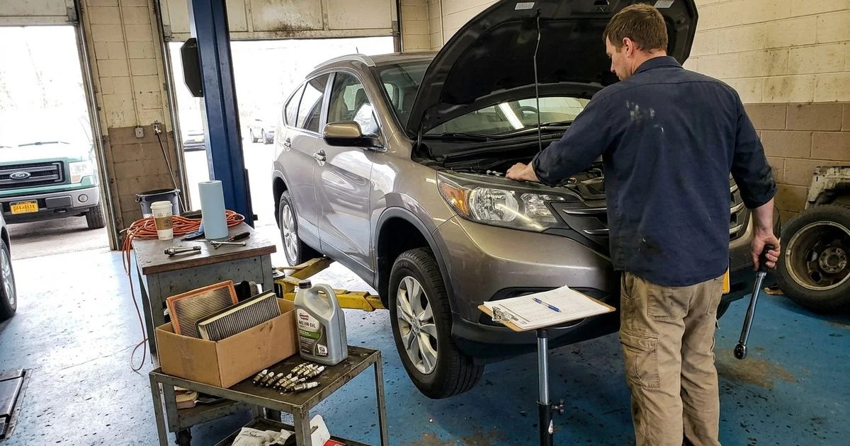 Technician performing scheduled maintenance with a checklist, New Britain shop, candid