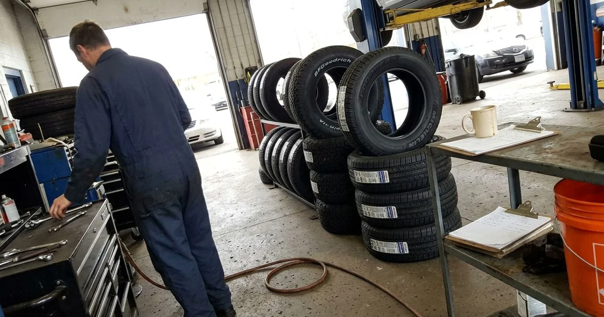 Row of new tires from several brands on a shop rack, natural light, candid