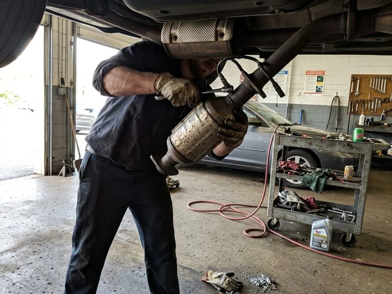 Catalytic converter being removed with oxygen sensor visible