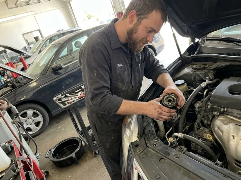 Technician inspecting a used oil filter during service